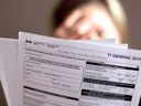 A woman looks at a tax return form in Toronto.